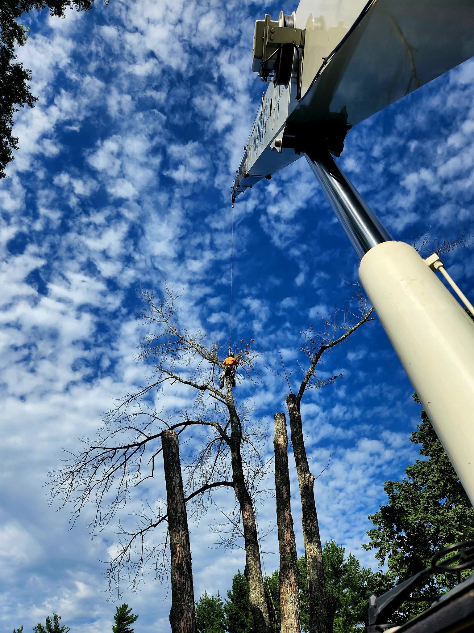 Climber and crane on a bright blue sky day