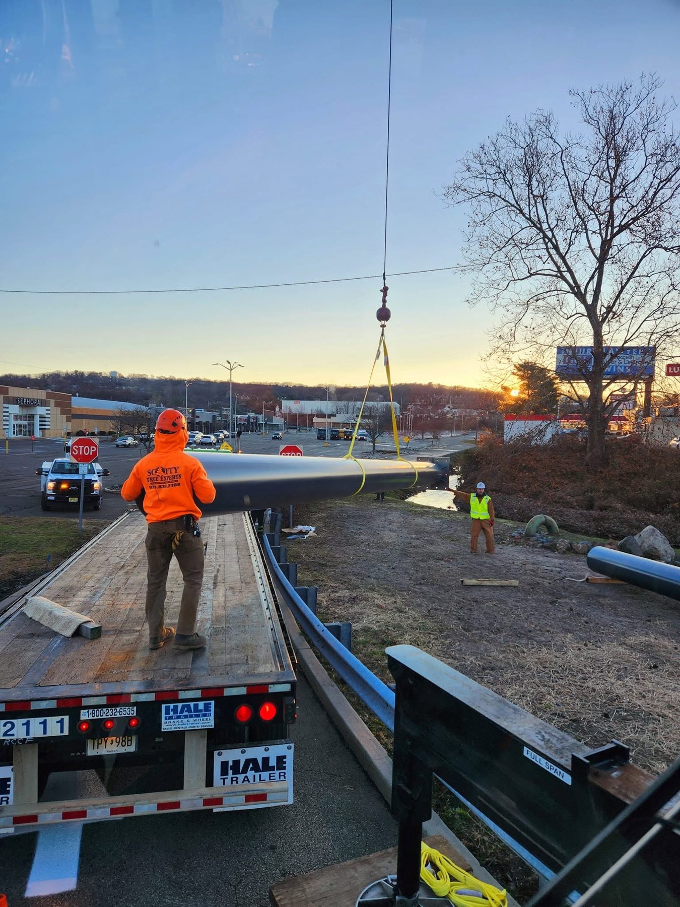 Commercial sign support pole handled using a crane at a roadside job