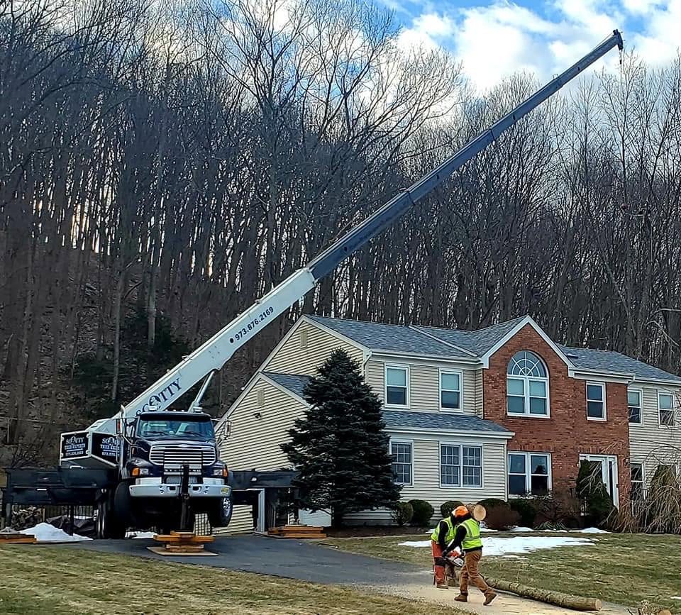 Scotty crane set up beside a residence with crew on site