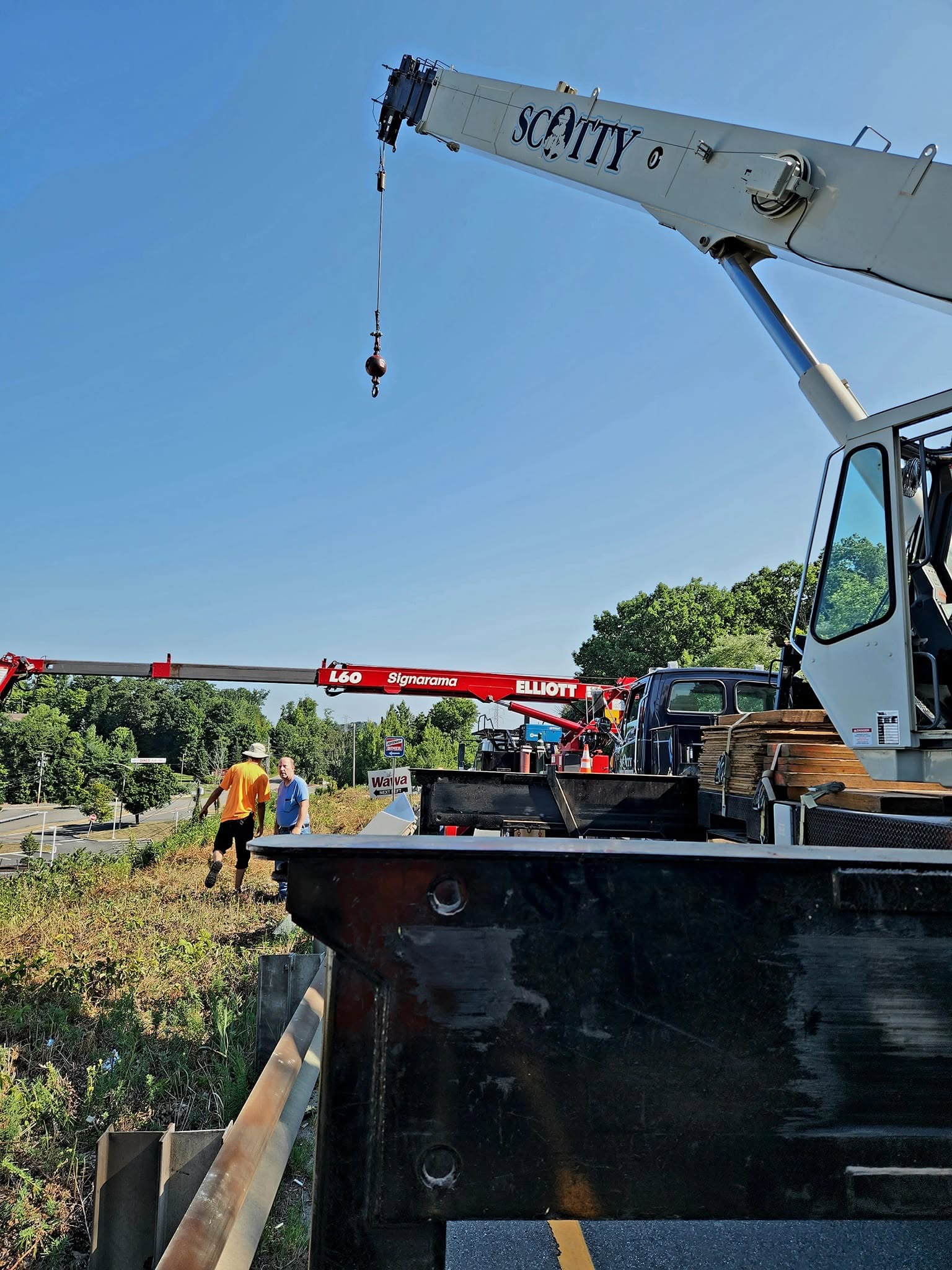 Scotty Tree Experts crane supporting a roadside sign project